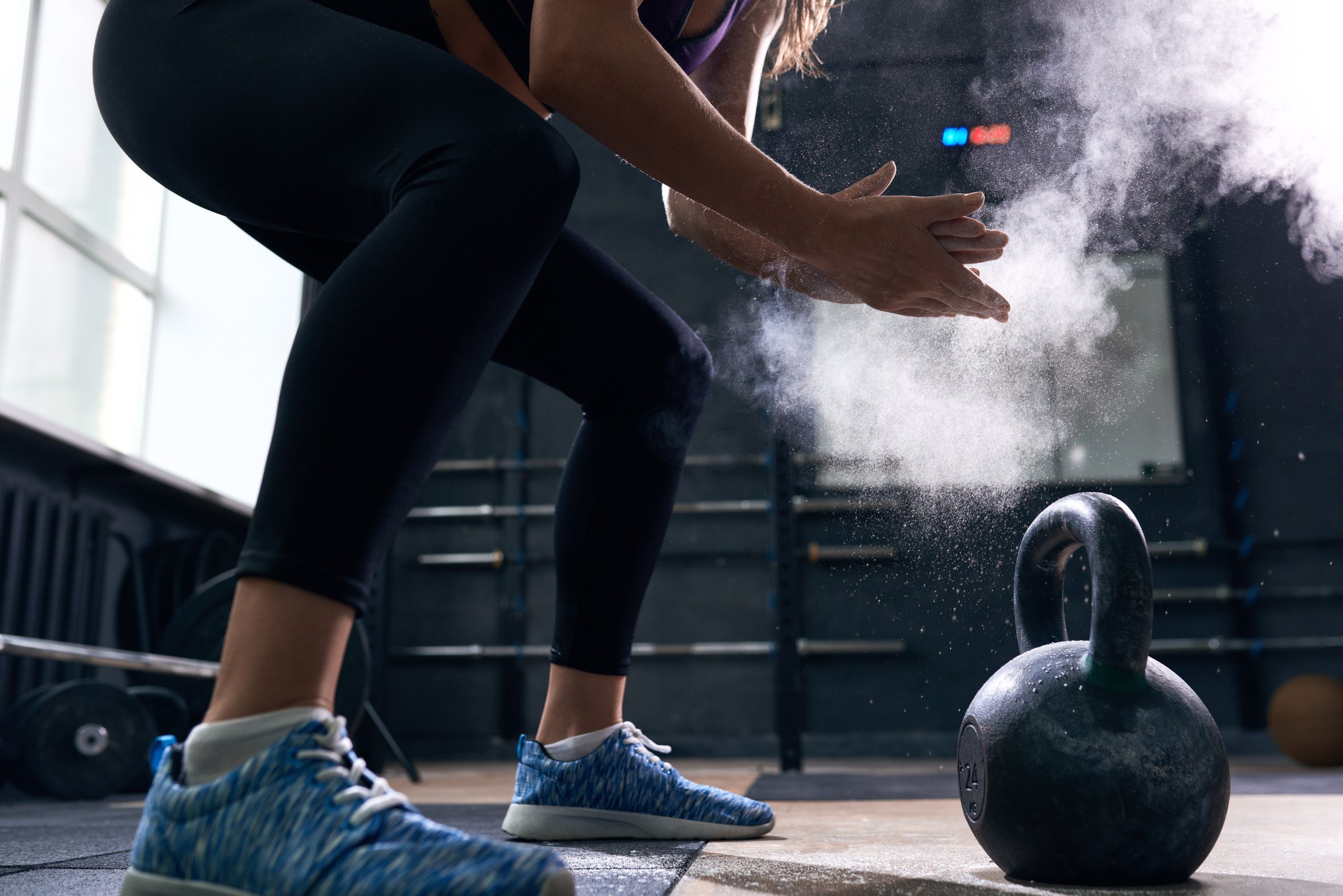 Young Woman Lifting Kettlebells in gym Gym