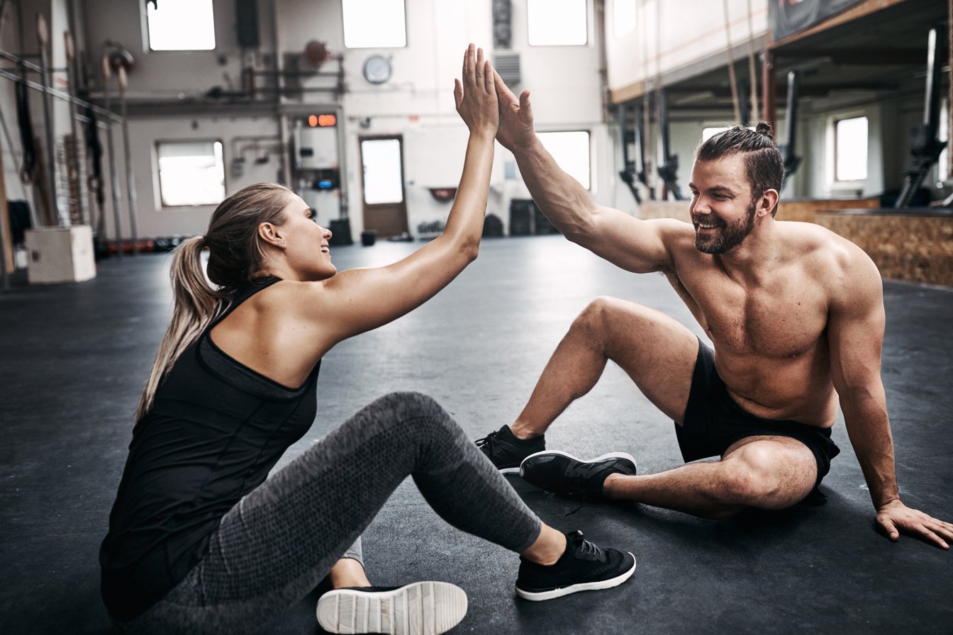 Two Fit Young People High Fiving Together after a Workout